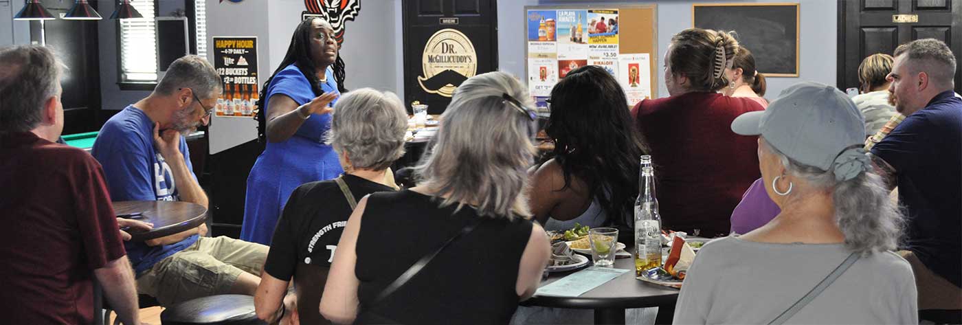 Dr. Vanessa Enoch speaking to a Democratic community group